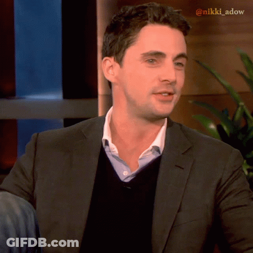A Man In A Suit And Sweater With The Name Nikki Adow On The Bottom Right GIF