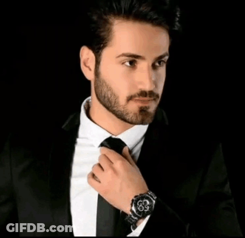 Man In Suit Adjusting Tie With Arabic Writing Above GIF