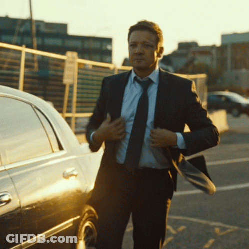 A Man In A Suit And Tie Adjusts His Tie GIF