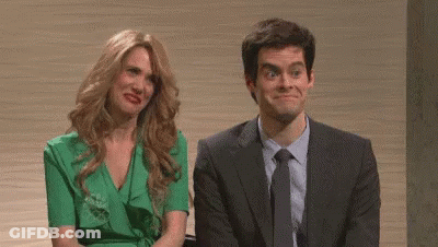 A Man In A Suit And Tie And A Woman In A Green Dress Are Sitting Next To Each Other Making Funny Faces . GIF