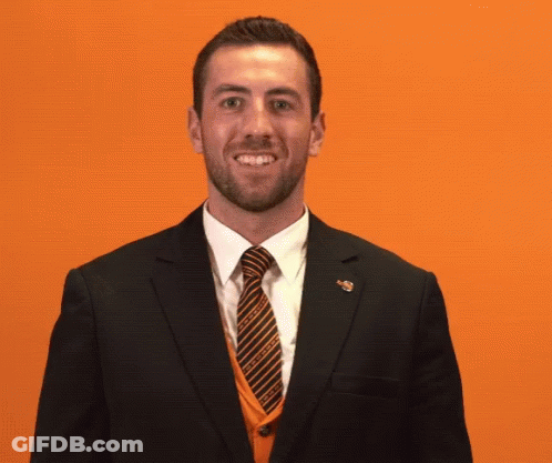 A Man In A Suit And Tie Covering His Mouth GIF