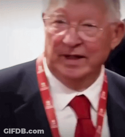 A Man In A Suit And Tie Has A Lanyard Around His Neck That Says ' Lg ' GIF