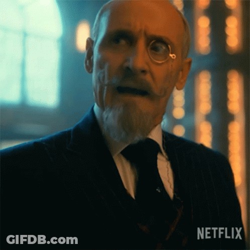 A Man In A Suit And Tie Has A Netflix Logo On The Bottom Left GIF