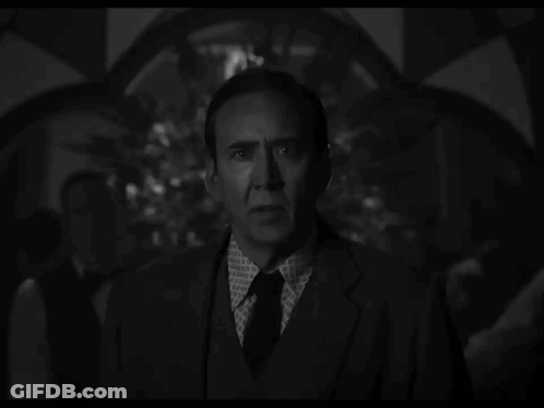 A Man In A Suit And Tie Has A Pattern On His Shirt GIF
