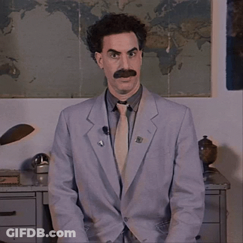 A Man In A Suit And Tie Has A Pin On His Jacket That Says ' A ' GIF