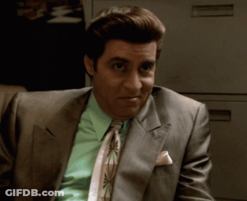 A Man In A Suit And Tie Has A Pink Pocket Square GIF