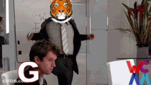 A Man In A Suit And Tie Has A Tiger Head On His Head And The Letter G Is Next To Him GIF