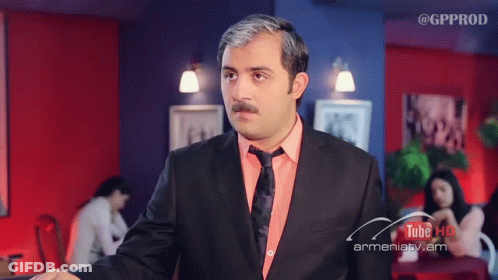 A Man In A Suit And Tie Has The Word Iya On His Chest GIF