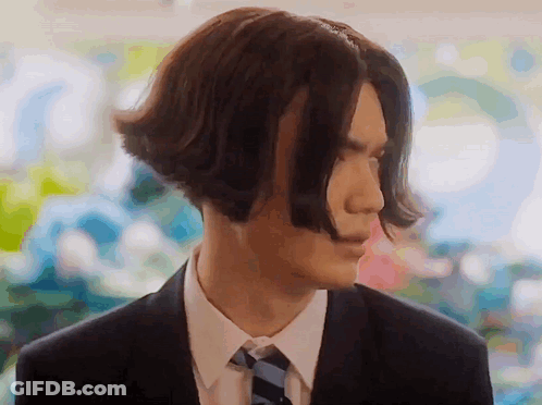 A Man In A Suit And Tie Has Very Long Hair . GIF