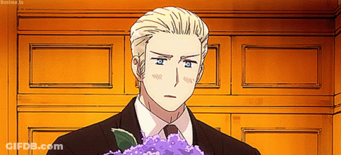 A Man In A Suit And Tie Holding A Bouquet Of Purple Flowers GIF