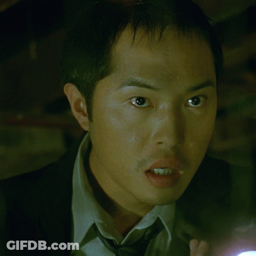 A Man In A Suit And Tie Holding A Flashlight GIF