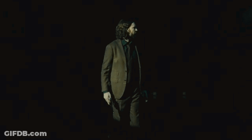 Man In Suit Holding Two Guns GIF