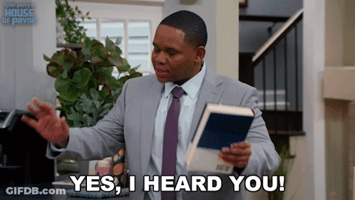 A Man In A Suit And Tie Holds A Book And Says " Yes I Heard You " GIF