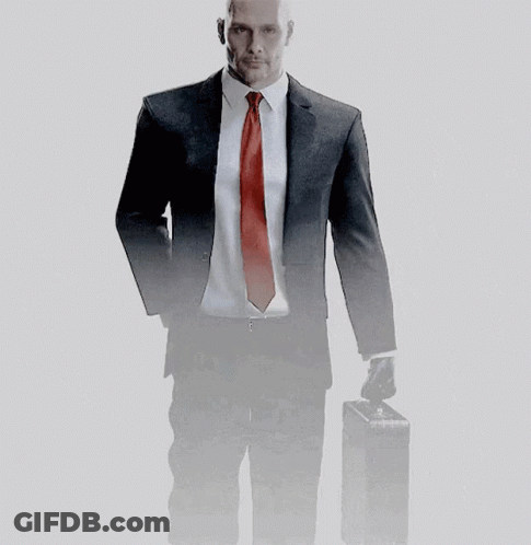 A Man In A Suit And Tie Holds A Briefcase GIF