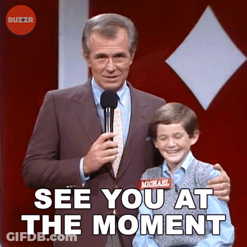 A Man In A Suit And Tie Holds A Microphone Next To A Boy With A Name Tag That Says Michael On It GIF