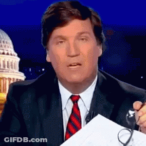 A Man In A Suit And Tie Holds A Pair Of Glasses GIF