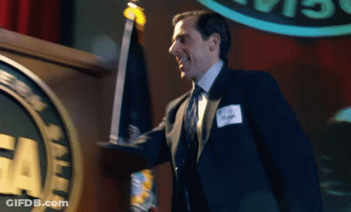 A Man In A Suit And Tie Holds A Trophy In Front Of A Podium With The Word Cia On It GIF