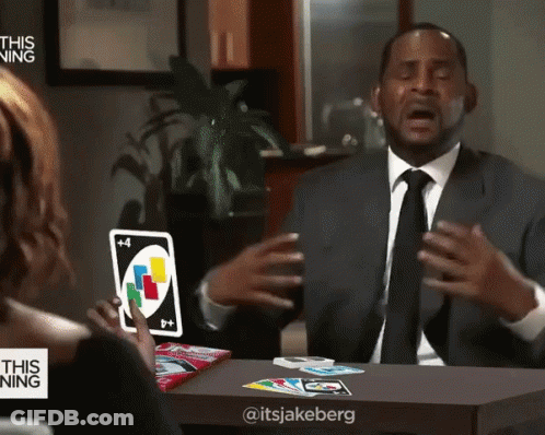 A Man In A Suit And Tie Holds A Uno Card GIF
