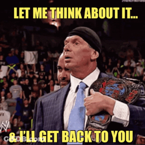 A Man In A Suit And Tie Holds A Wrestling Championship Belt And Says Let Me Think About It GIF