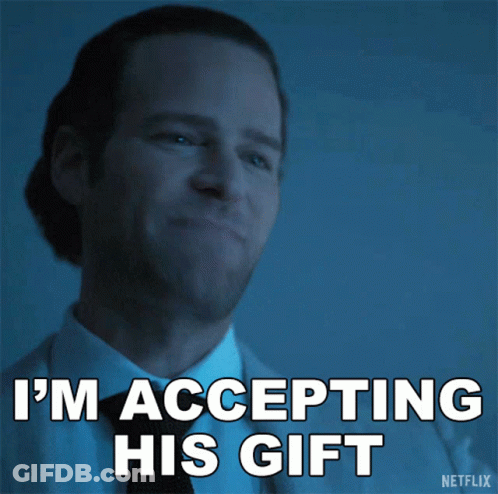A Man In A Suit And Tie Is Accepting His Gift GIF