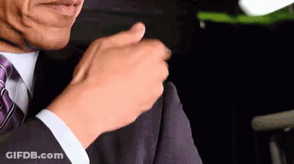 A Man In A Suit And Tie Is Adjusting His Jacket Sleeve . GIF