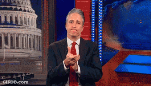 A Man In A Suit And Tie Is Applauding In Front Of A Capitol Building GIF