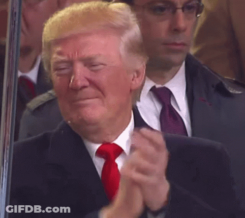 A Man In A Suit And Tie Is Applauding GIF