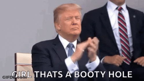 A Man In A Suit And Tie Is Applauding While Sitting Next To Another Man . GIF