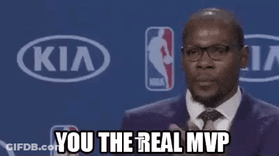 A Man In A Suit And Tie Is Applauding While Standing In Front Of A Kia Sign . GIF