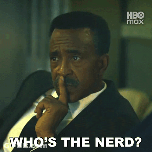 A Man In A Suit And Tie Is Asking " Who 'S The Nerd " GIF