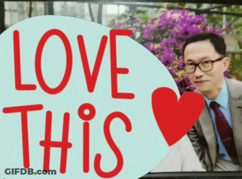 A Man In A Suit And Tie Is Behind A Sign That Says " Love This " GIF
