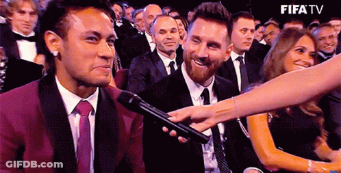A Man In A Suit And Tie Is Being Interviewed By A Woman In A Crowd Of People . GIF
