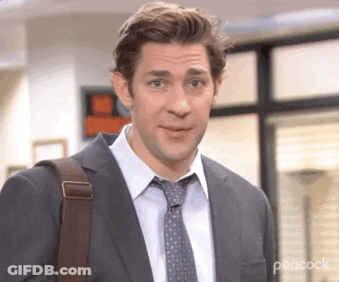 A Man In A Suit And Tie Is Carrying A Bag . GIF