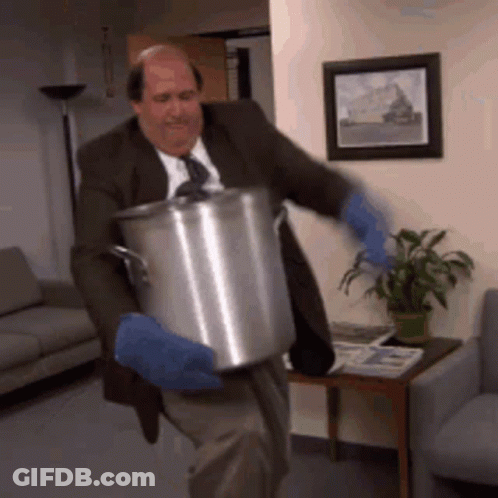 A Man In A Suit And Tie Is Carrying A Pot GIF