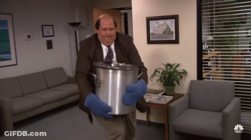 A Man In A Suit And Tie Is Carrying A Pot With A Nbc Logo On The Bottom GIF