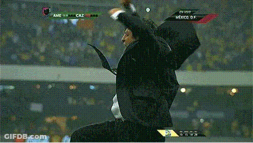 A Man In A Suit And Tie Is Celebrating In Front Of A Scoreboard That Says Ame Caz GIF