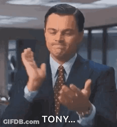 A Man In A Suit And Tie Is Clapping His Hands And Saying `` Tony ... '' . GIF