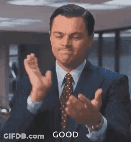 A Man In A Suit And Tie Is Clapping His Hands And Says `` Good '' . GIF