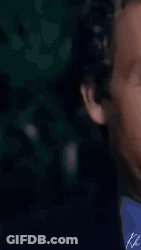 A Man In A Suit And Tie Is Clapping His Hands In A Close Up . GIF