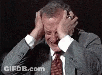 A Man In A Suit And Tie Is Covering His Ears GIF