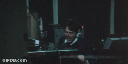 A Man In A Suit And Tie Is Covering His Ears With His Hands And The Word Argh Is Written Above Him GIF