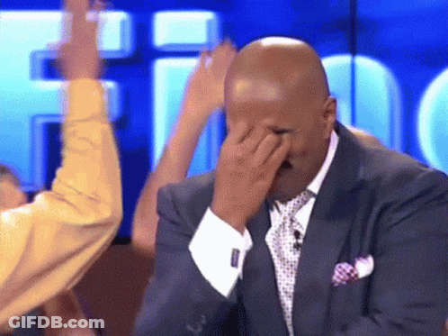 A Man In A Suit And Tie Is Covering His Face GIF