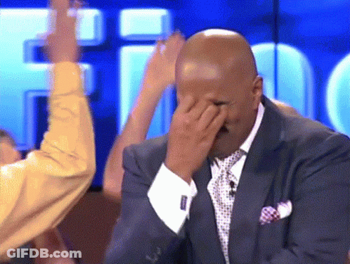 A Man In A Suit And Tie Is Covering His Face GIF