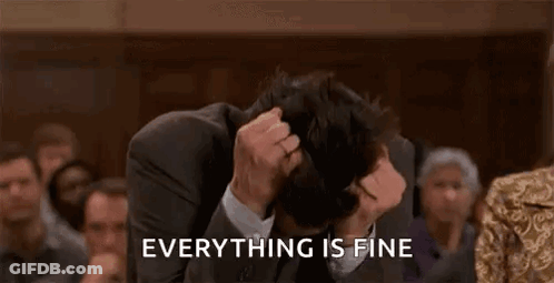 A Man In A Suit And Tie Is Covering His Face With His Hands While A Crowd Watches . GIF
