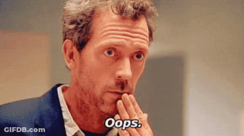 A Man In A Suit And Tie Is Covering His Mouth With His Hand And Saying Oops . GIF