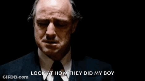 A Man In A Suit And Tie Is Crying In A Dark Room And Says `` Look At How They Did My Boy '' . GIF