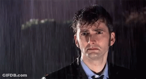 A Man In A Suit And Tie Is Crying In The Rain GIF