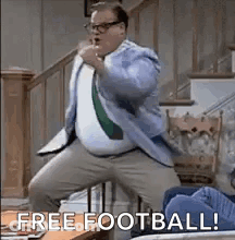 A Man In A Suit And Tie Is Dancing In A Living Room With The Words `` Free Football ! '' GIF