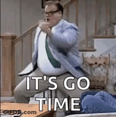 A Man In A Suit And Tie Is Dancing In A Living Room With The Words `` It 'S Go Time '' Above Him . GIF