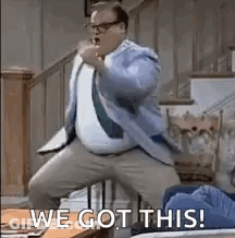 A Man In A Suit And Tie Is Dancing In A Living Room With The Words `` We Got This ! '' GIF